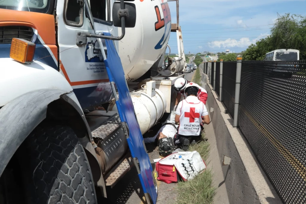 Motociclista queda atrapado bajo revolvedora tras accidente en carretera internacional