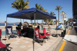 Familias apartan sus lugares para disfrutar del tradicional desfile de Carnaval en Mazatlán, como desde hace años